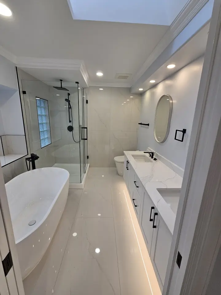 Renovated Capilano bathroom with a freestanding tub, glass shower and large-format tile