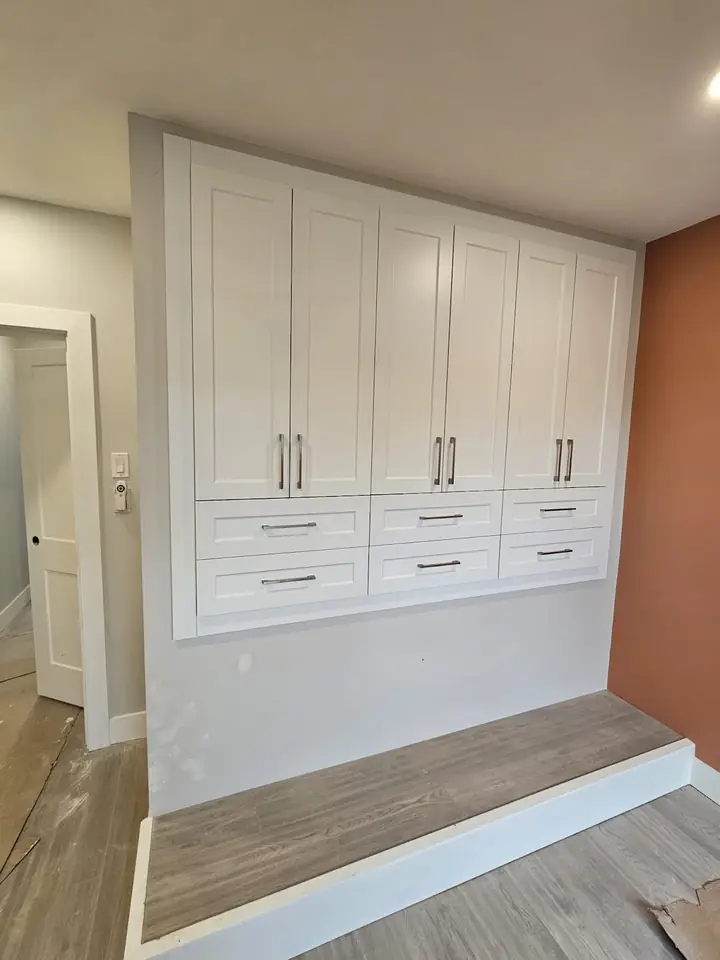 Built-in storage wall with cabinets, drawers and a bench seat in a Capilano home