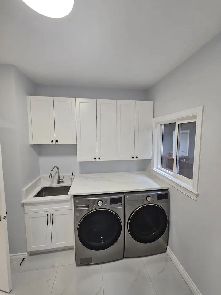 Laundry room with upper and lower cabinets and a sink beside the washer and dryer, Capilano
