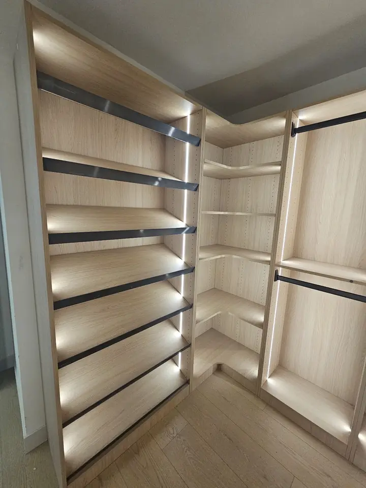 Walk-in closet in Coquitlam with lit shelving and hanging rods