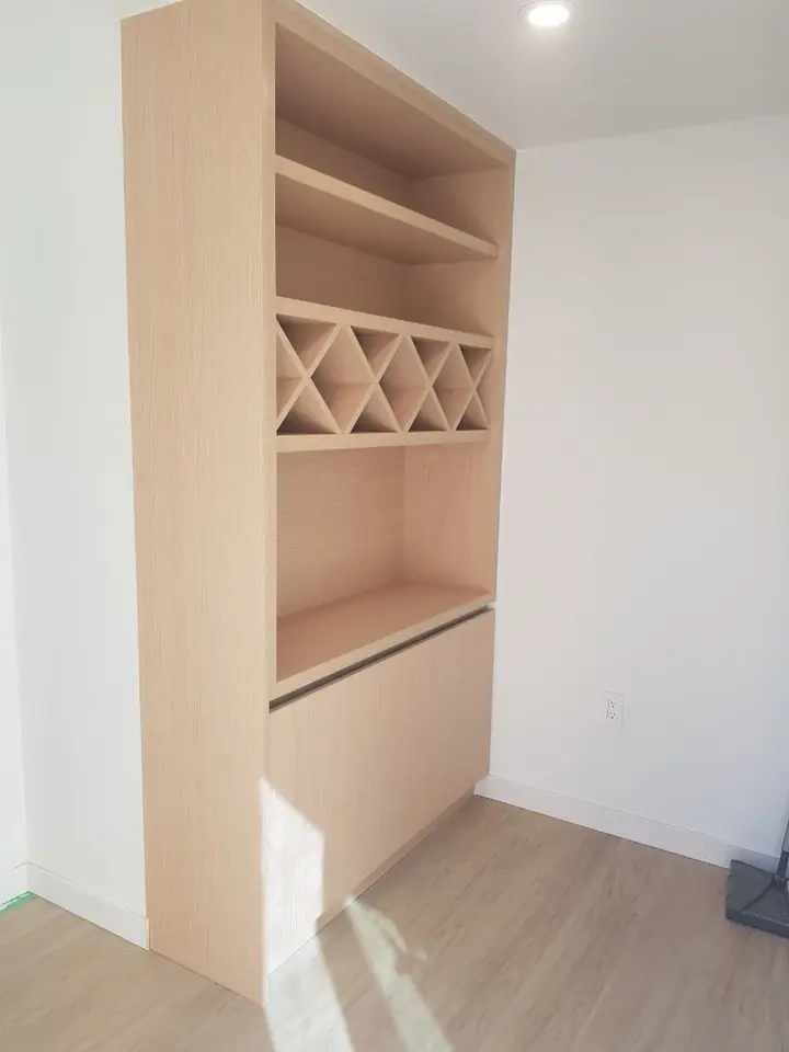 Built-in bookshelf with a wine rack and lower cabinet in a Delbrook home