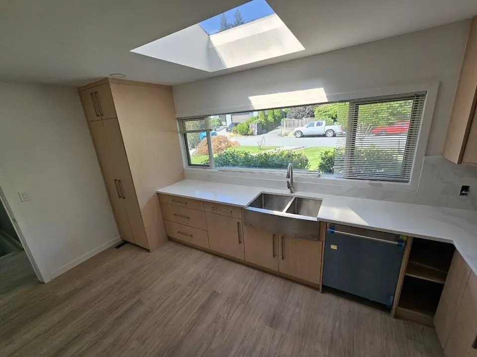 Renovated Delbrook kitchen with custom wood cabinetry under a skylight