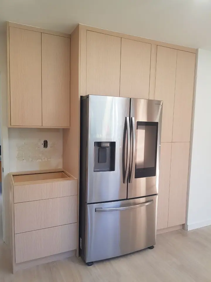 Tall custom pantry cabinets built around the fridge in the Delbrook kitchen