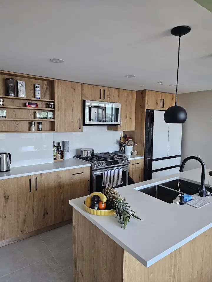 Island with sink and wood cabinetry in the renovated Downtown Vancouver kitchen