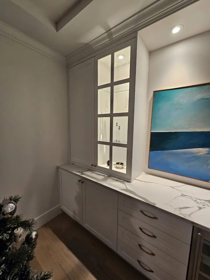 Glass-door display cabinet with lighting beside the art niche, Dundarave