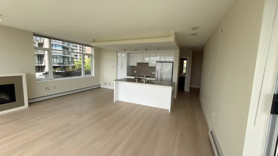 Lonsdale home after renovation: open living room and kitchen with new light flooring