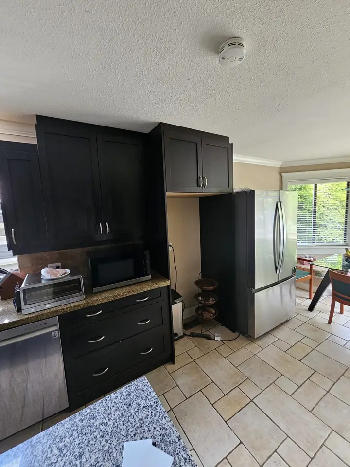 Dark cabinetry and tile flooring in the North Vancouver kitchen before renovation