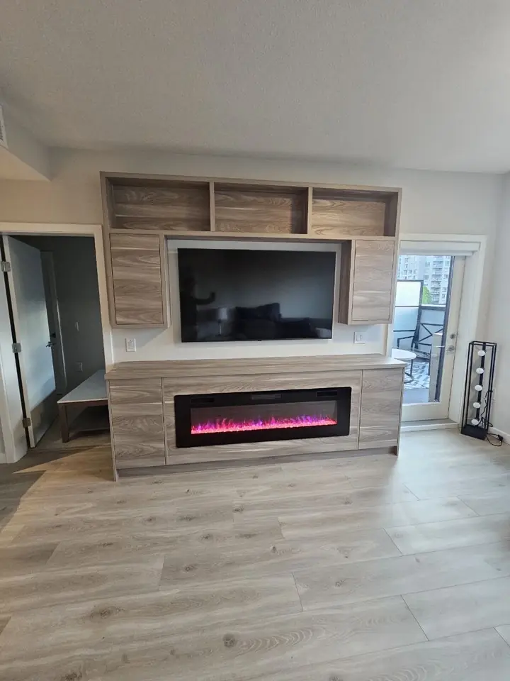 Custom TV wall with open shelving and a built-in electric fireplace in a Vancouver home