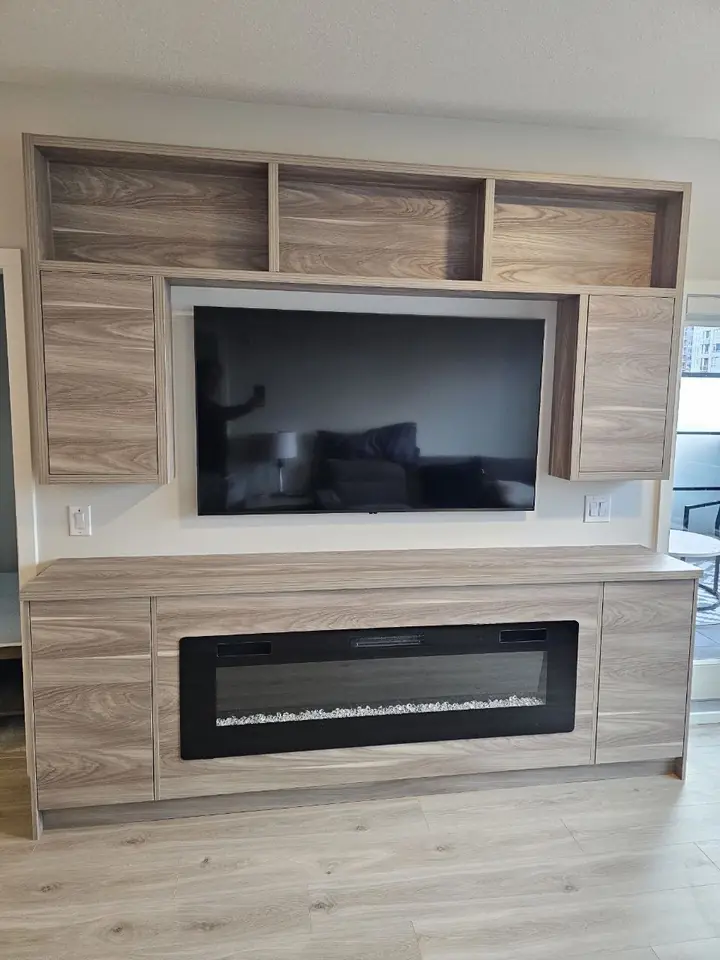 Built-in TV wall with wood-look panels, upper shelves and a fireplace insert