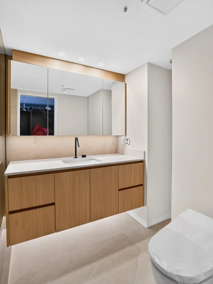 Floating wood vanity with under-vanity lighting in the remodelled Yaletown bathroom