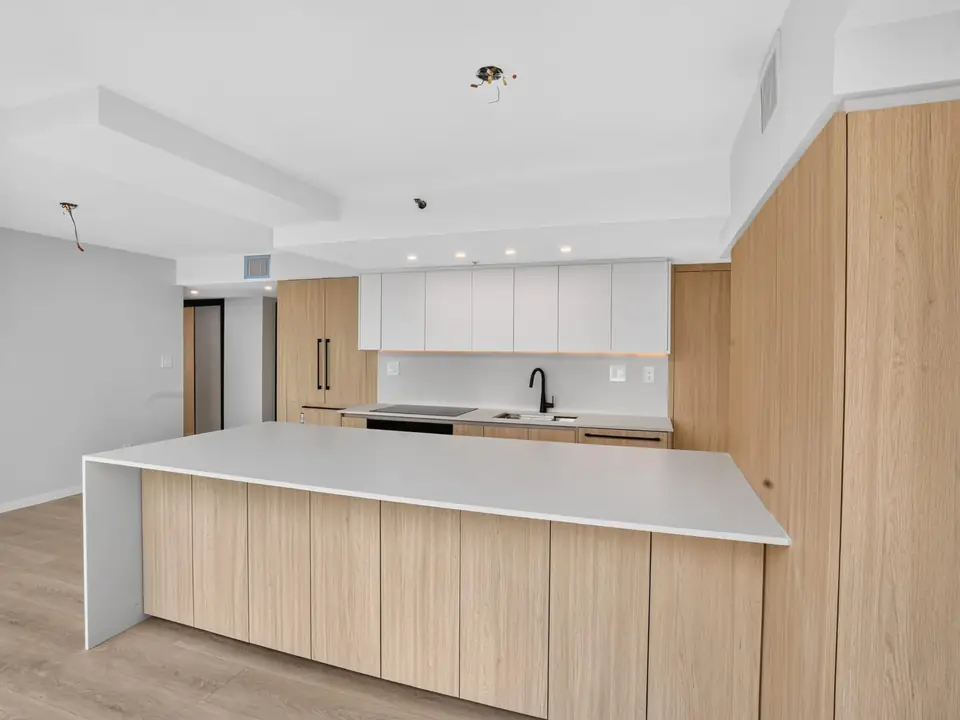 Wood-fronted kitchen island with a white countertop in the renovated Yaletown home