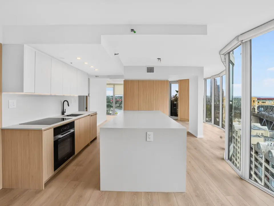 Yaletown kitchen after the remodel: wood lower cabinets, white upper cabinets and a white island